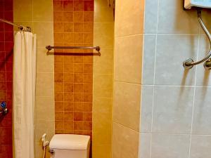 a bathroom with a toilet and a shower at Authong Residence in North Pattaya