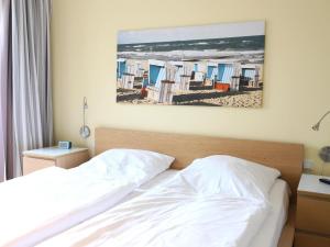um quarto com uma cama e uma pintura da praia em Brandenburger Straße 5b, Whg.7 em Westerland