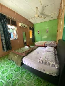two beds in a room with green walls at B'first Chalet Perhentian Island in Kuala Besut