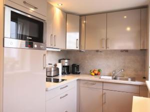 eine Küche mit weißen Schränken und einem Waschbecken in der Unterkunft Ferienhaus mit neuen und sehr hochwertigen Appartements in zentraler Lage in Westerland in Westerland