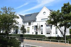ein großes weißes Haus mit Solardach in der Unterkunft Ferienhaus mit neuen und sehr hochwertigen Appartements in zentraler Lage in Westerland in Westerland