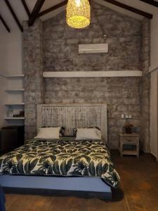 a bedroom with a bed and a brick wall at Hermosa casa en Cauca Viejo in Jericó
