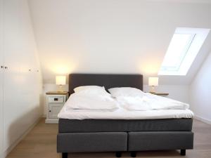 ein Bett in einem Schlafzimmer mit zwei Lampen an zwei Tischen in der Unterkunft Ferienhaus mit neuen und sehr hochwertigen Appartements in zentraler Lage in Westerland in Westerland