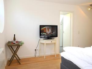 ein Wohnzimmer mit einem TV auf einem kleinen Tisch in der Unterkunft Ferienhaus mit neuen und sehr hochwertigen Appartements in zentraler Lage in Westerland in Westerland