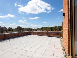 a patio with a brick wall and blue sky at Modern Apartments with Balcony in Merton near Wimbledon by Sojo Stay in Mitcham