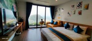 a bedroom with a bed and a large window at Flamingo Ibiza Hai Tien in Nam Khê
