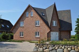 une grande maison en briques avec un toit en gambrel dans l'établissement Am Loo 8b, List, à List auf Sylt