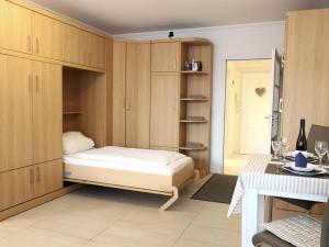 1 dormitorio con 1 cama y armarios de madera en Sueßes Appartement im Zentrum von Westerland in unmittelbarer Strandnähe, en Westerland