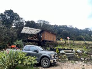 a truck parked in front of a tiny house at Mirador Bosque Gran Torino Neusa in Cogua