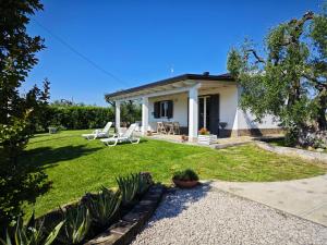 a small white house with a patio and grass at Villa leone 2 in Pisticci