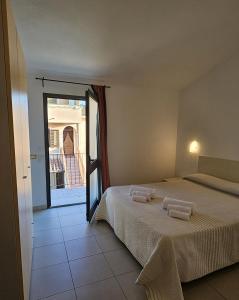 a bedroom with a bed with two towels on it at Albergo Residenziale Stella Dell'Est in Bari Sardo