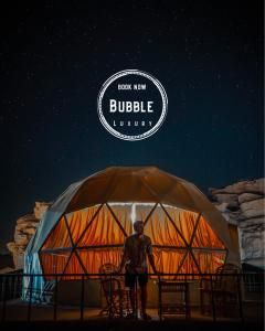 a man standing in front of a large tent at Wadi rum Bubble luxury camp in Wadi Rum