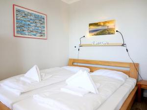 - 2 lits dans une chambre avec des draps blancs dans l'établissement Kampstraße 3, W49, à Westerland