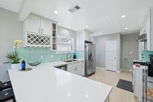 a kitchen with white cabinets and a white counter top at 5 Mins Walk To Oldtown Monrovia Cozy 4 Br Home in Monrovia
