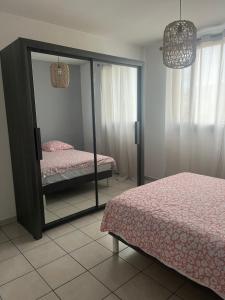 1 dormitorio con 2 camas individuales y espejo en Appart T3 proche métro -draps et serviettes inclus, en Marsella