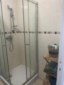 a shower with a glass door in a bathroom at Appart T3 proche métro -draps et serviettes inclus in Marseille