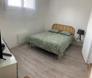 a bedroom with a bed in a white room at La P'tite Véronnaise in Savigny-en-véron