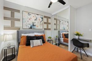 a bedroom with a bed with an orange bedspread at 5 Mins Walk To Oldtown Monrovia Cozy 4 Br Home in Monrovia