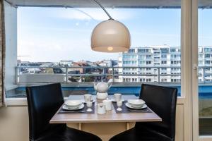 une table à manger avec des chaises et une grande fenêtre dans l'établissement Hanseatenhaus, W71, à Westerland