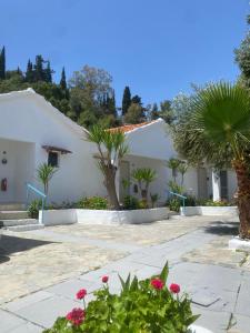 a white building with palm trees and flowers at ARTAKi R APARTMENTS in Koroni