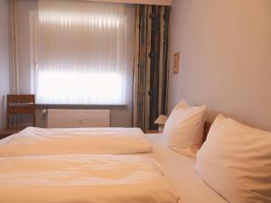 Gartenstr. 6c, W38 في فيسترلاند: غرفة نوم بسرير وملاءات بيضاء ونافذة