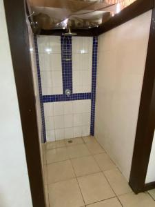 a bathroom with a shower with blue and white tiles at Serenity Bungalows in Port-Olry