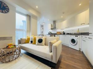 Una sala de estar con un sofá y una cocina. en Central Luton Apartment, en Luton