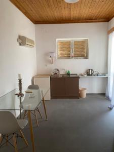 a kitchen with a table and chairs in a room at ARTAKi R APARTMENTS in Koroni