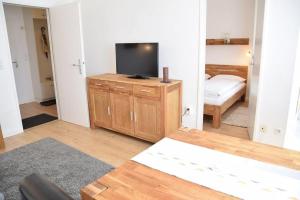 ein Wohnzimmer mit einem TV auf einem Holzschrank in der Unterkunft Die 2 Zimmerwohnung mit Balkon liegt in der 1 Etage und ist ideal für 2 bis 3 Personen in Westerland