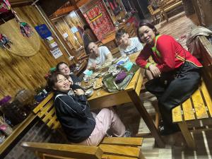un groupe de personnes assises à une table dans un restaurant dans l'établissement Hoa Chanh Eco Home, à Sa Pa