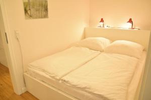 een wit bed met twee lampen erop bij Kiarwai 4B W.10 in Tinnum