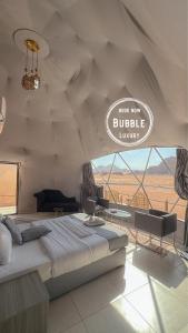 een slaapkamer met een bed en een bord met de tekst 'Begraven luxe' bij Wadi rum Bubble luxury camp in Wadi Rum