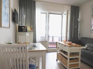 una pequeña sala de estar con mesa y sofá en Appartement mit 2 Balkonen, en Westerland