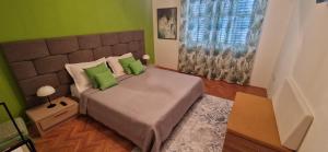una camera da letto con un grande letto con due cuscini verdi di Villa Croatia Trogir, Center, 4 rooms, parking, jacuzzi, free beach and pool 15 min a Trogir