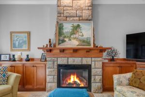 - un salon avec une cheminée et un tableau au-dessus dans l'établissement Elegant Boise River Home at Bown Crossing with Hot Tub, à Boise