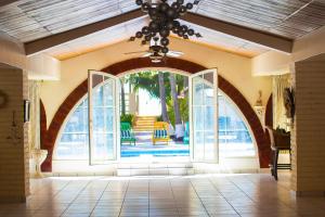 una entrada abierta a una casa con una lámpara de araña en Rancho de Playa Angie's Resort en San Luis La Herradura