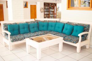 sofá con cojines azules en la sala de estar en Rancho de Playa Angie's Resort, en San Luis La Herradura
