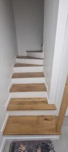 escalera con paredes blancas y suelo de madera en Appartement pré de Paris, en Gagny