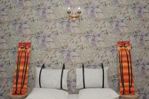 達累斯薩拉姆的住宿－House - King Beds - 5G Wi-Fi - Hottub -PS4，一间设有两个枕头的房间和鲜花的墙壁