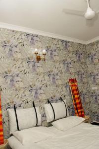 1 dormitorio con 1 cama y papel pintado con motivos florales en House - King Beds - 5G Wi-Fi - Hottub -PS4, en Dar es Salaam