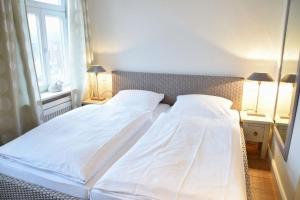 2 camas blancas en un dormitorio con ventana en Bundiswung 9 Whg. 4, GB2, en Westerland