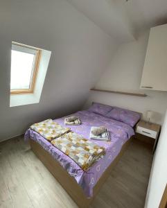 um pequeno quarto com uma cama roxa com sapatos em Divcibarski cardak em Divčibare