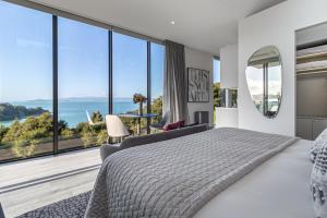a bedroom with a large bed and large windows at Omana Luxury Villa in Rocky Bay