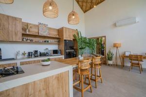 uma cozinha com armários de madeira e uma mesa e cadeiras em NEW! Viva la Vida Villa - 2BR Villa in Kerobokan em Kerobokan