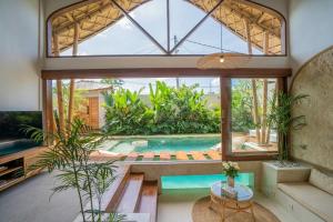 uma sala de estar com uma piscina e uma grande janela em NEW! Viva la Vida Villa - 2BR Villa in Kerobokan em Kerobokan