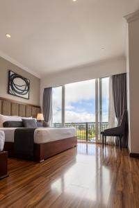 a bedroom with a large bed and a balcony at Hotel Grand Turf By GSP in Nuwara Eliya