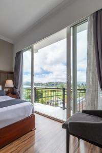 a bedroom with two beds and a balcony at Hotel Grand Turf By GSP in Nuwara Eliya