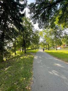 un sendero en un parque con árboles y una persona en bicicleta en Cozy lake view room by city center, en Kuopio