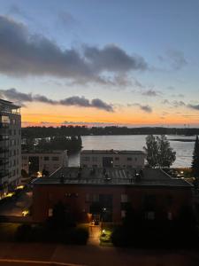 a view of a river at sunset from a building at Cozy lake view room by city center in Kuopio