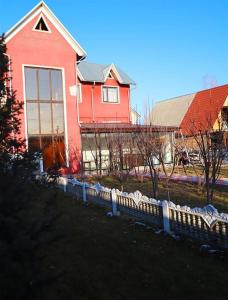czerwony dom z płotem przed nim w obiekcie Adorable 3 bedroom house villa with mountain view and beautiful garden w mieście Baytyk